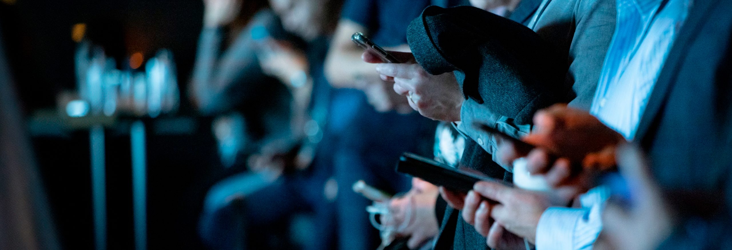 Hands of people using their smart phones.
